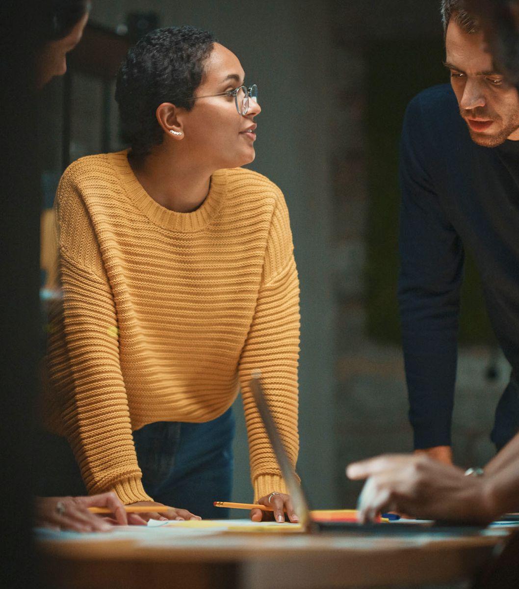 Three individuals working together around a table.