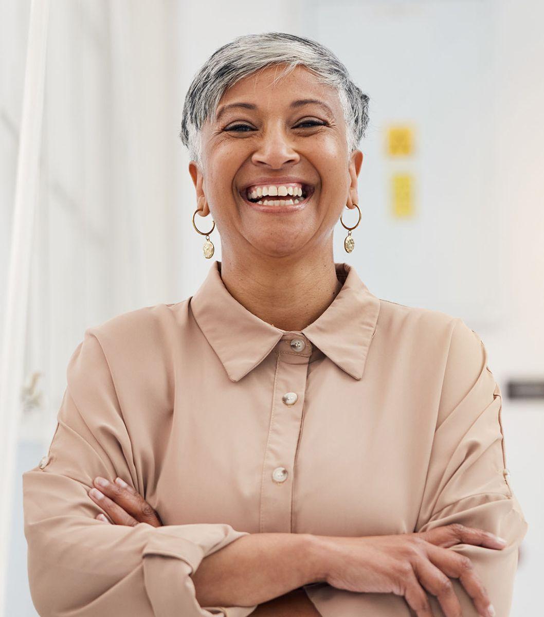 Women with arms crossed smiling.