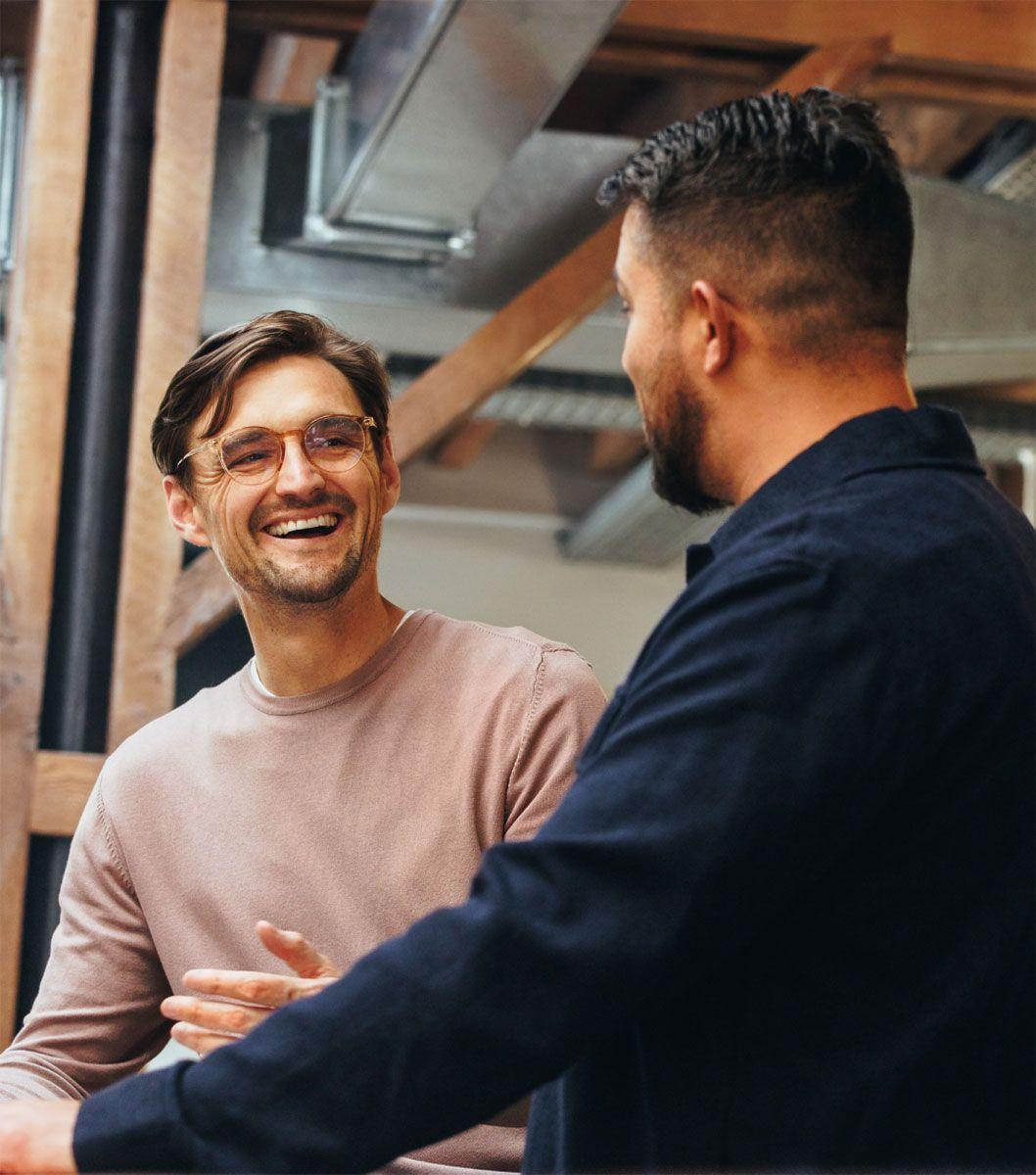 Two men talking to each other in an industrial modern setting.