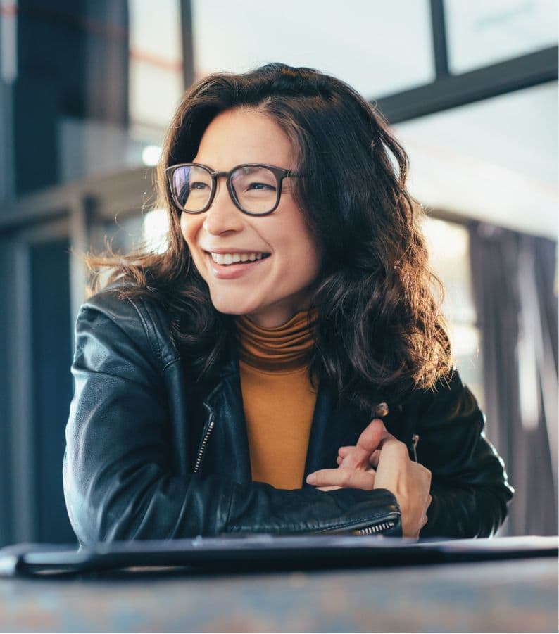 A young smiling woman discussing Guideline's 401(k) retirement savings plan solution with a group of coworkers.